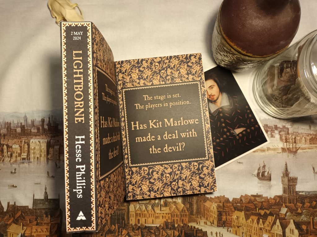 Color photo of a pair of books decorated in black and gold damask print lying on top of Wenceslas Hollar's Panorama of early modern London. One book is shown face-up, the other displays the spine, which reads "2 May 2024 LIGHTBORNE Hesse Phillips." The cover on the other book features a black square framing the tagline, "The stage is set. The players are in position. Has Kit Marlowe made a deal with the Devil?" Peeking out from under neath the face-up book is a postcard of Christopher Marlowe's alleged portrait.